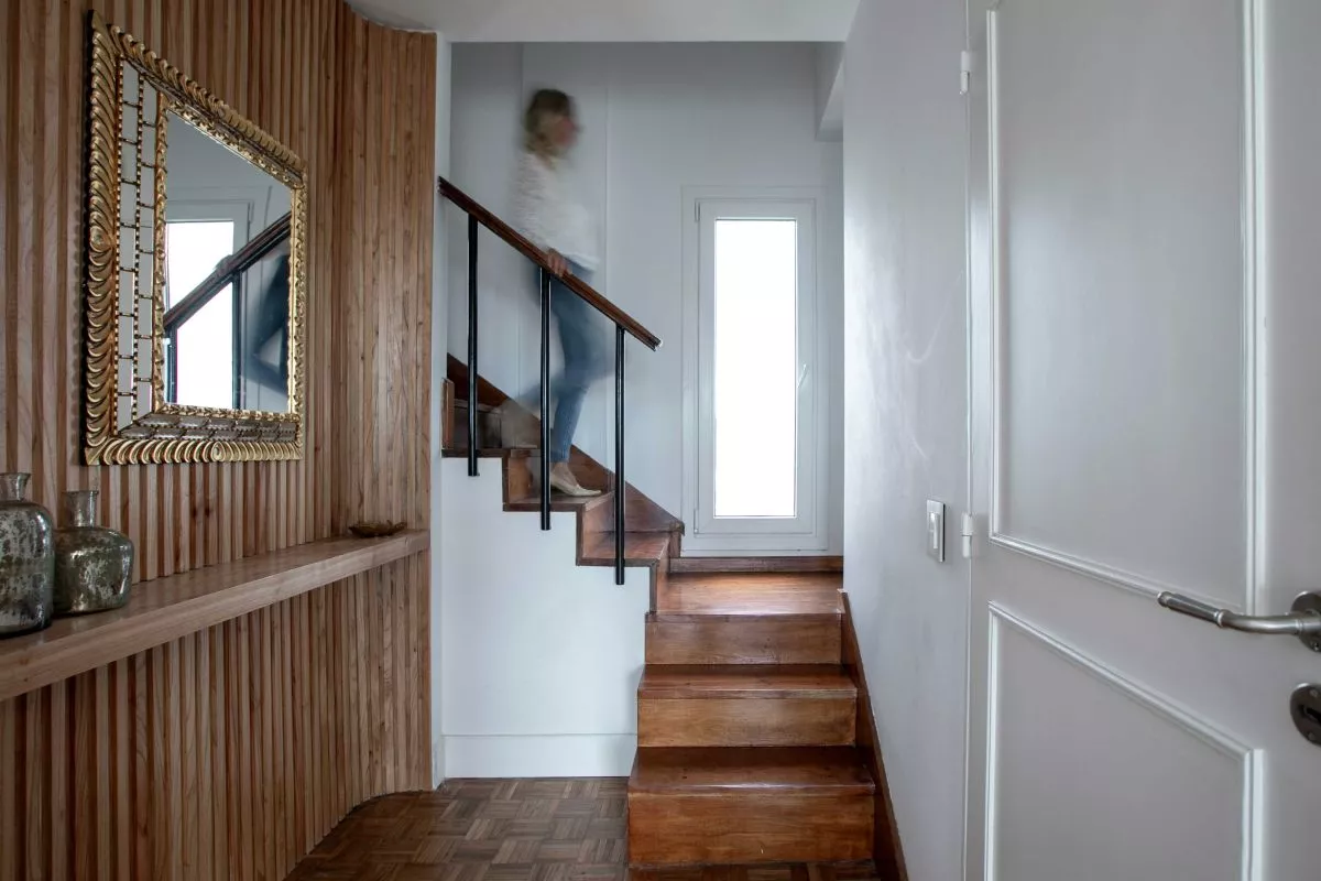 Comedor luminoso con piso de madera, mesa y sillas, y zócalo blanco alto EPS Maxi Line